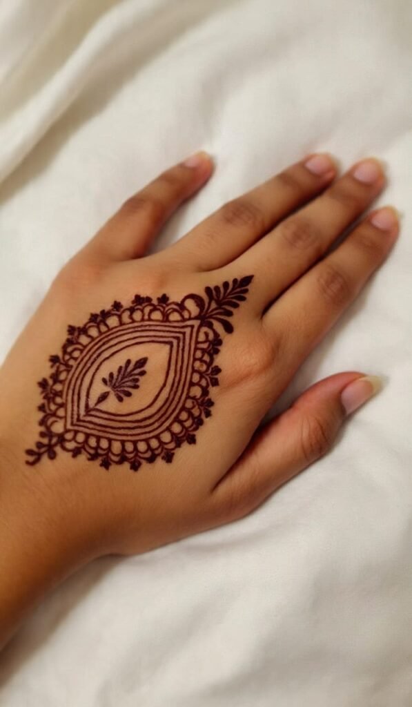 Mehendi design with round flower like pattern in the middle and design on one finger